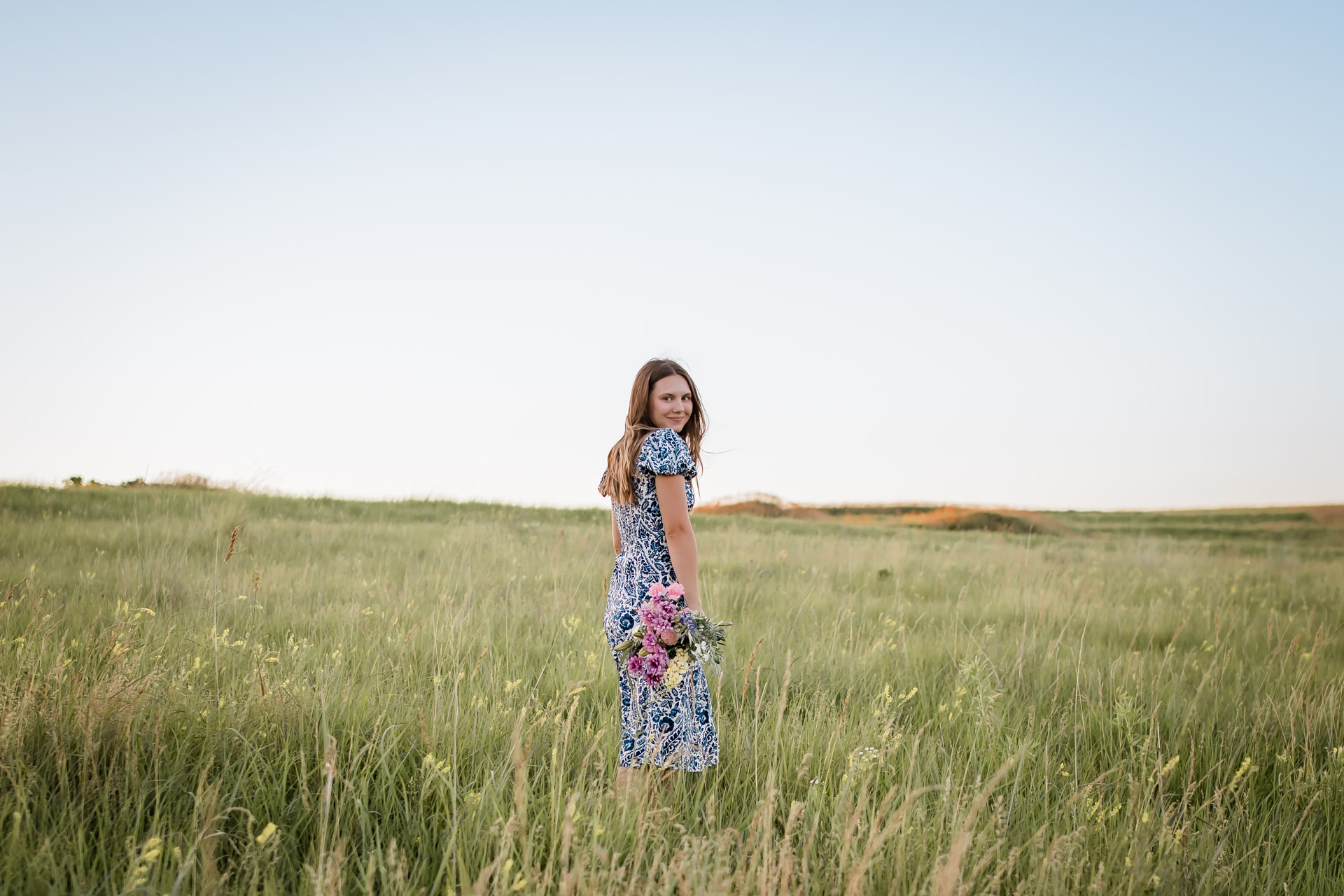 Young woman in wildflower field at golden hour